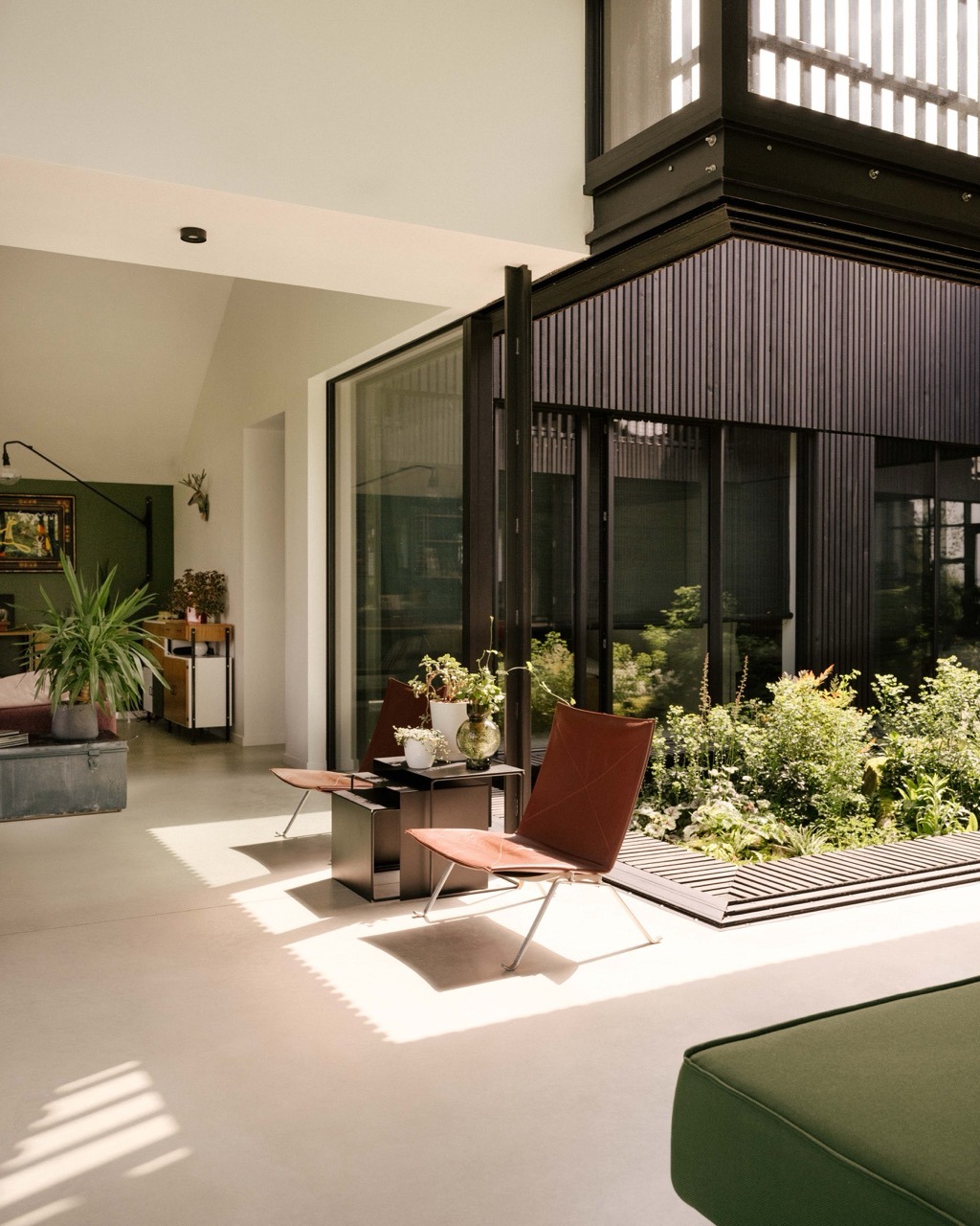 Salon ouvert structuré autour d’un patio avec ossature bois apparente